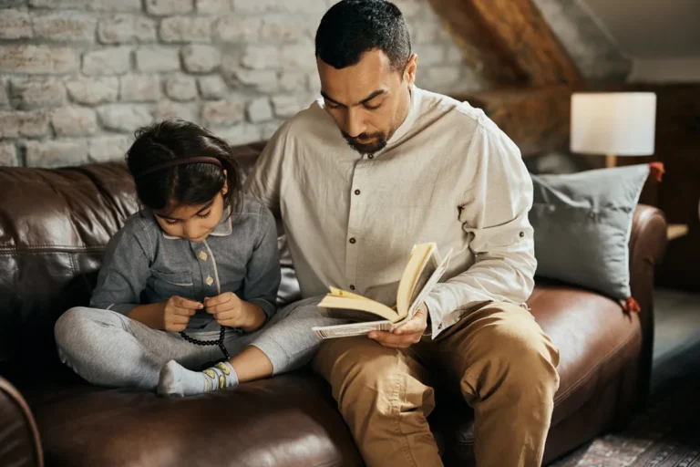 Dad and son sitting on the sofa reading a book together